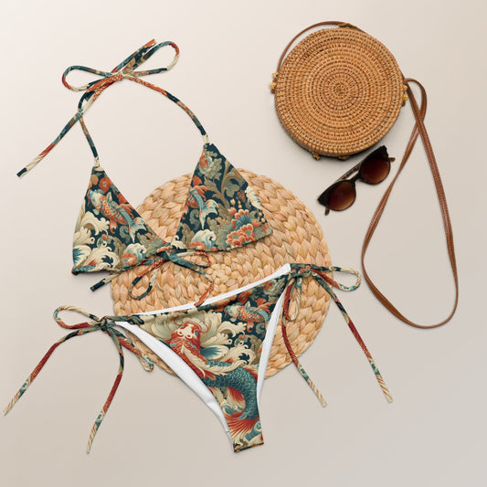 Vintage-inspired recycled string bikini set with floral print, styled with a straw handbag and sunglasses.