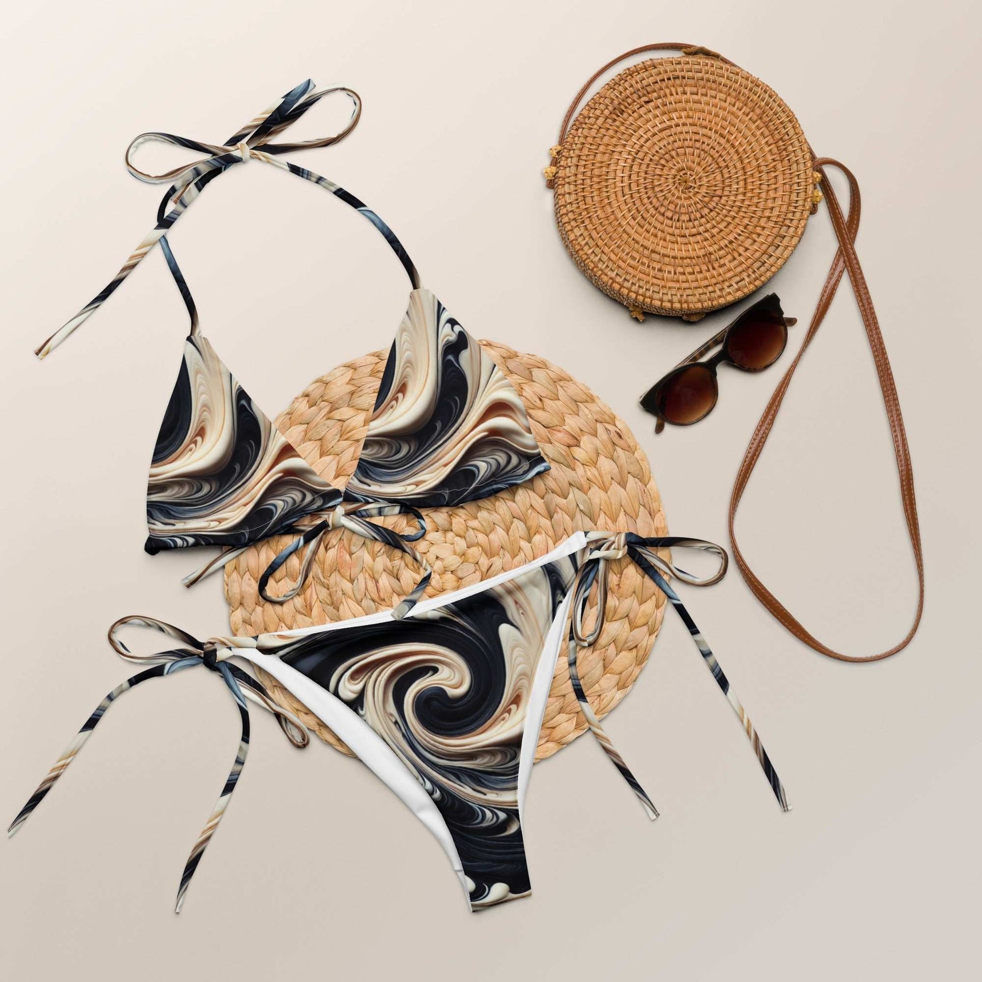 Elegant marble swirl string bikini set with UPF 50+ in black, gold, and beige, displayed with accessories.