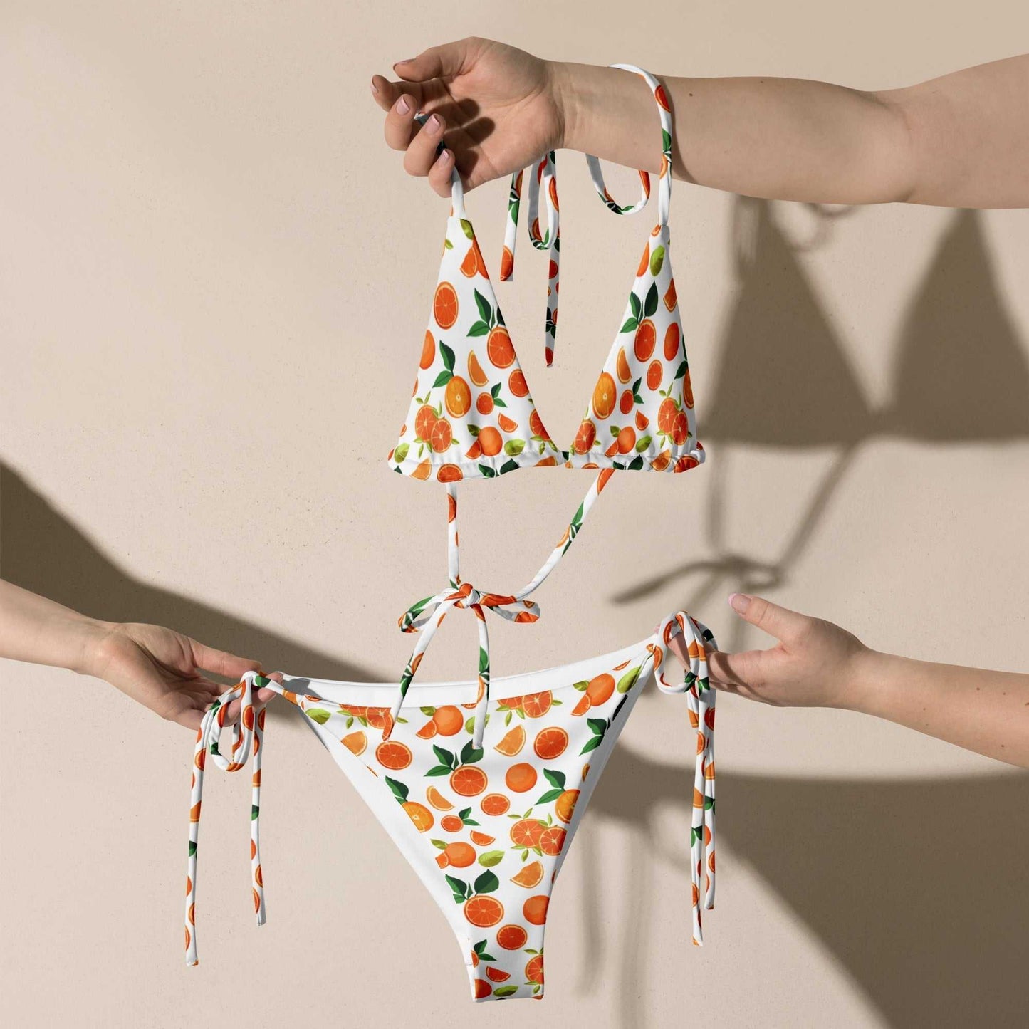 Citrus orange print string bikini set with vibrant orange and lemon pattern, UV protection, adjustable ties, removable padding, and inclusive sizing.