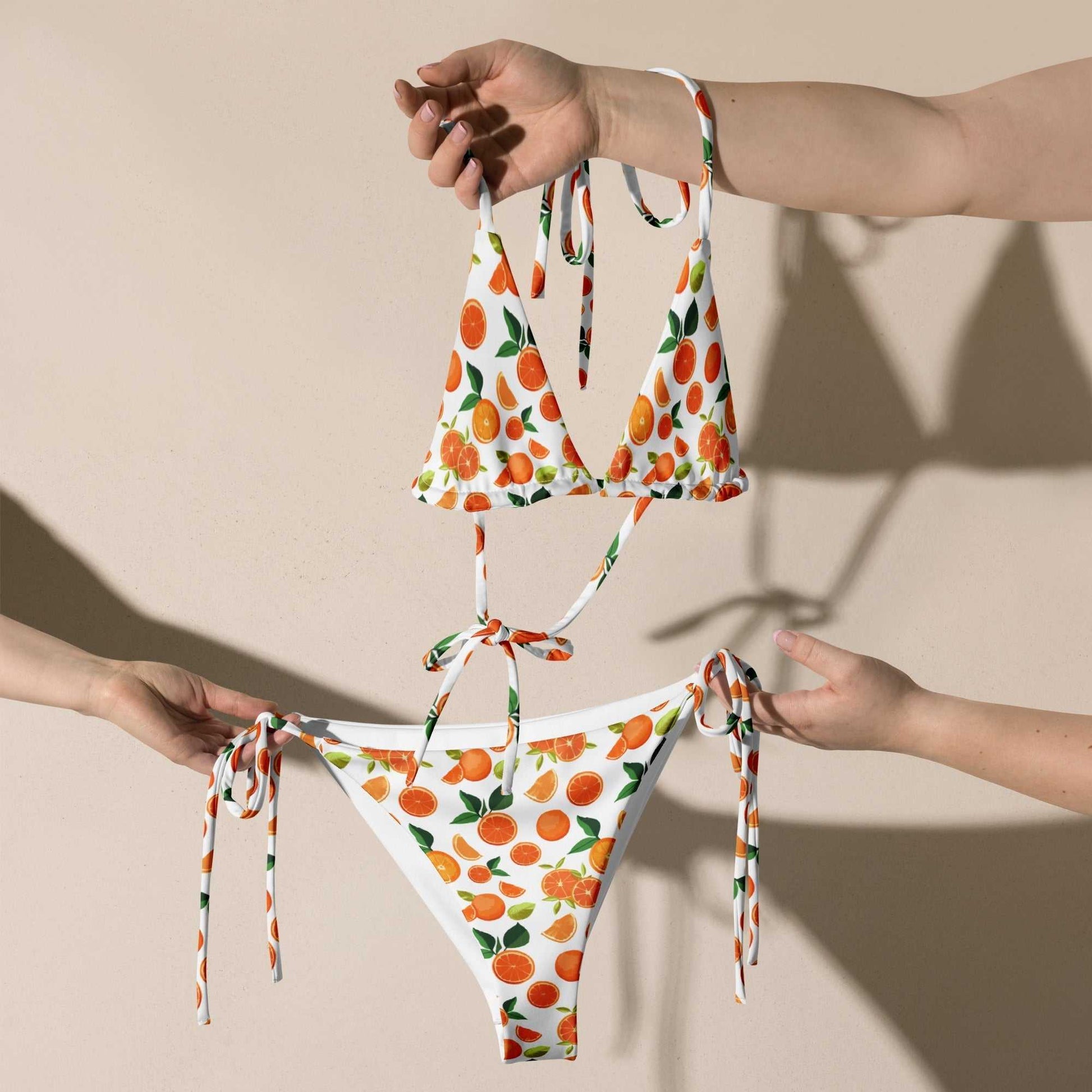 Citrus orange print string bikini set with vibrant orange and lemon pattern, UV protection, adjustable ties, removable padding, and inclusive sizing.