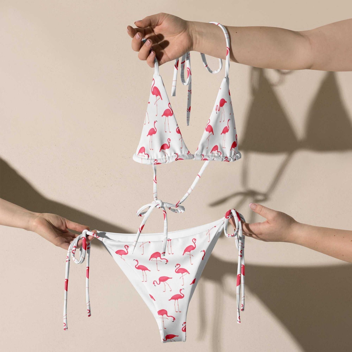Flamingo print halter bikini set with pink flamingos on white fabric, featuring adjustable neck tie and UPF 50+ protection.