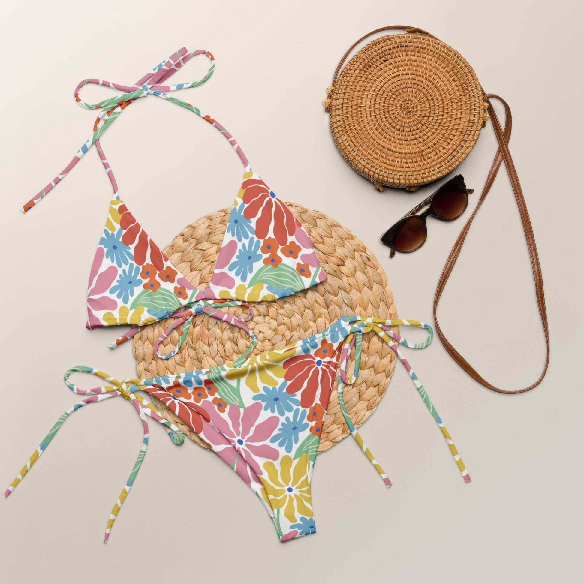 Vibrant tropical floral string bikini set with adjustable ties and UPF 50+ sun protection.