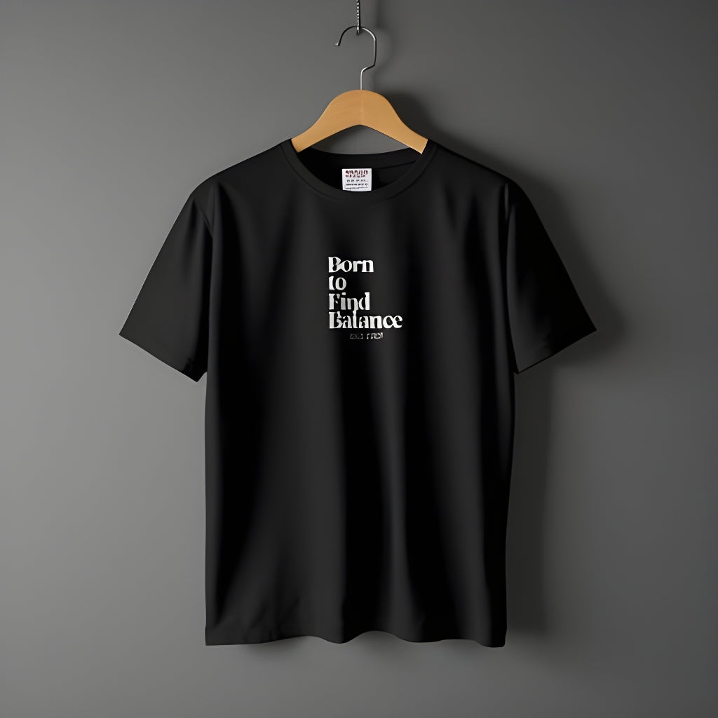 Born to Find Balance ESTD 2025 Graphic T-Shirt in black on a hanger.
