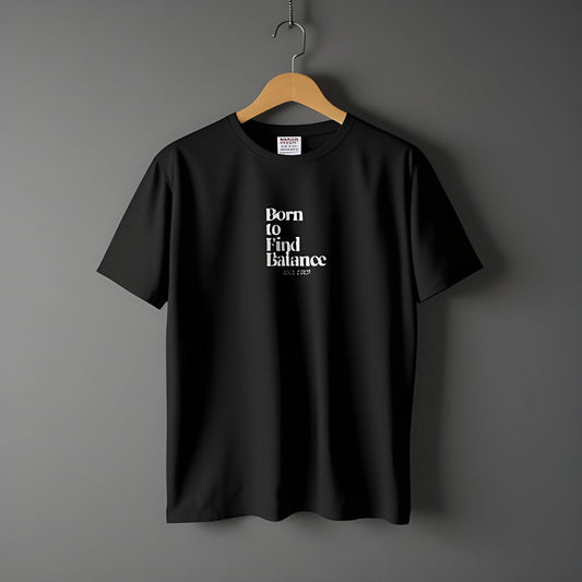 Born to Find Balance ESTD 2025 Graphic T-Shirt in black on a hanger.