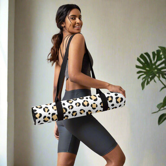 Yoga mat with leopard print design, featuring anti-slip rubber bottom and soft microsuede top, carried by a person.